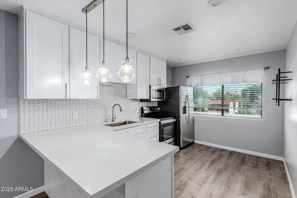 a kitchen with kitchen island a stove a sink a center island and wooden floor