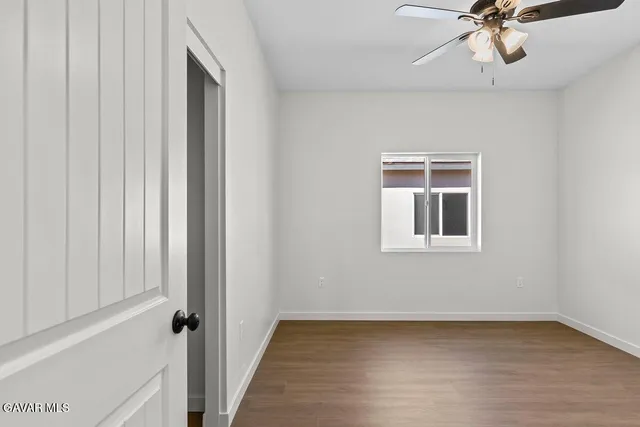 a view of a livingroom with a ceiling fan and wooden floor