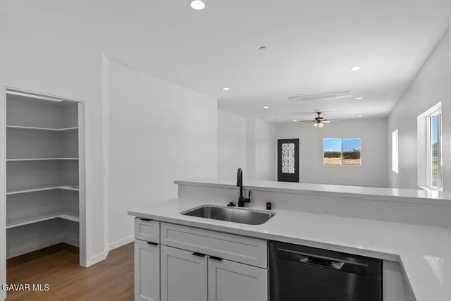 a kitchen with a sink cabinets and wooden floor