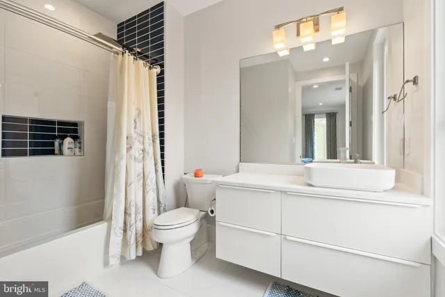 a bathroom with a sink a toilet a mirror and shower