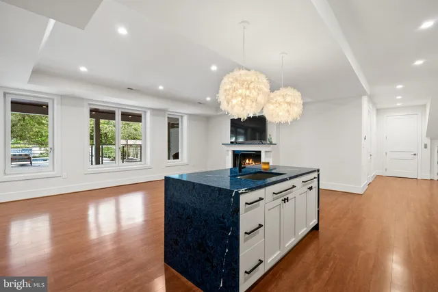 a kitchen that has a lot of white cabinets and wooden floor