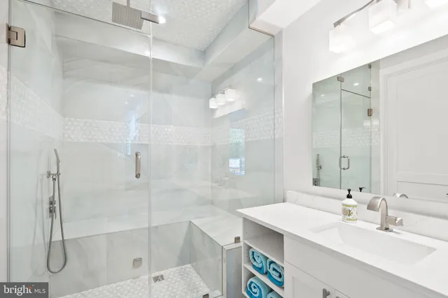 a bathroom with a shower sink vanity and mirror