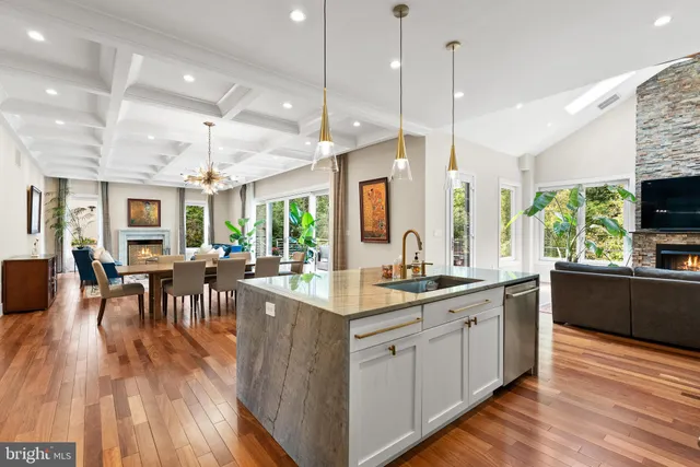 a kitchen with stainless steel appliances granite countertop a sink a stove and a wooden floors