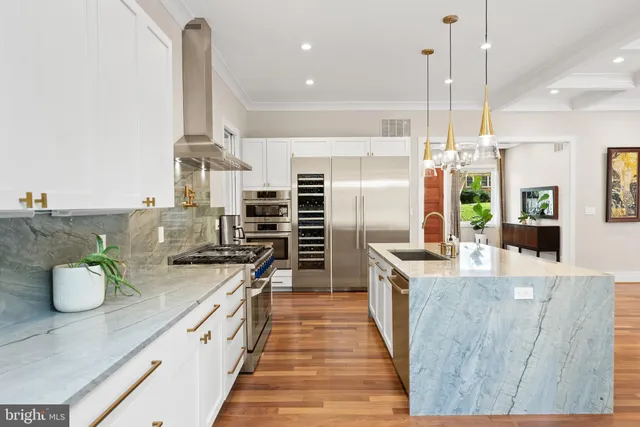 a view of a dining room and livingroom with furniture wooden floor kitchen chandelier