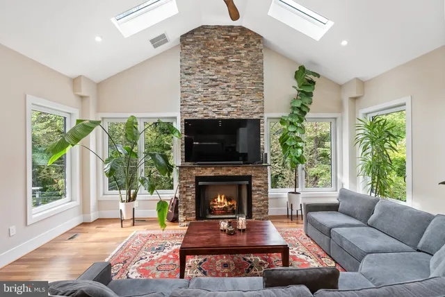 a living room with furniture a large window and a fireplace