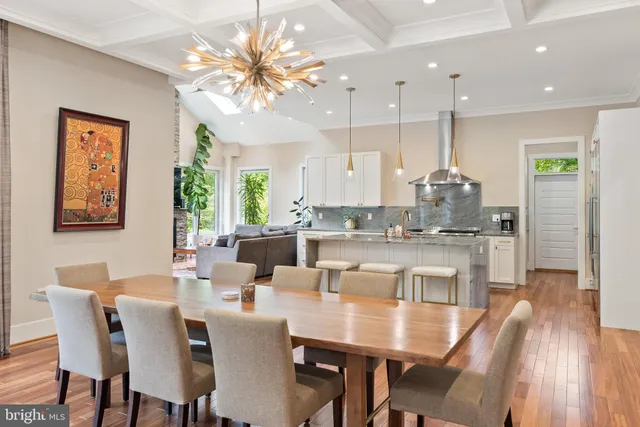a dining room with stainless steel appliances kitchen island granite countertop a dining table chairs and a refrigerator