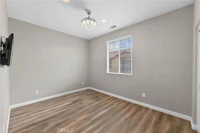 a view of a room with wooden floor and fan