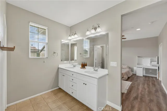 a spacious bathroom with a double vanity sink a mirror and a bathtub