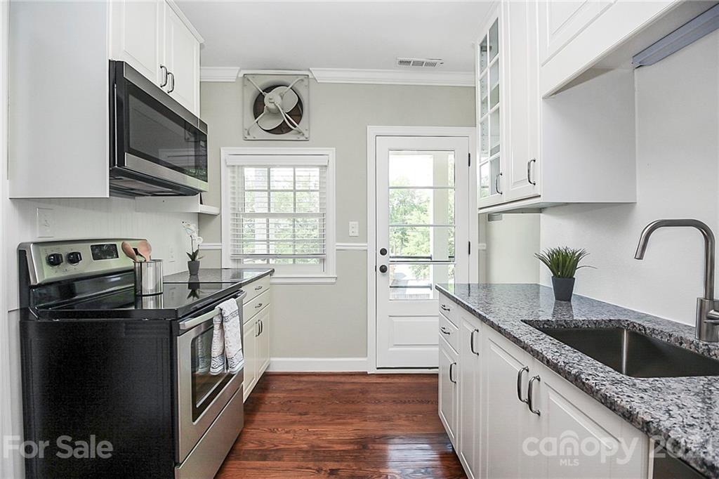 930 Ardsley Road, Unit B4 Charlotte, NC 28207 - Photo 19 of 35 a kitchen with stainless steel appliances granite countertop a sink stove microwave and cabinets