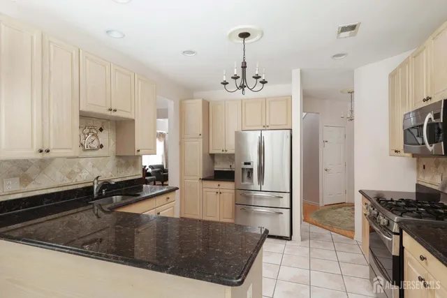 a kitchen with stainless steel appliances granite countertop a sink a stove a refrigerator and cabinets