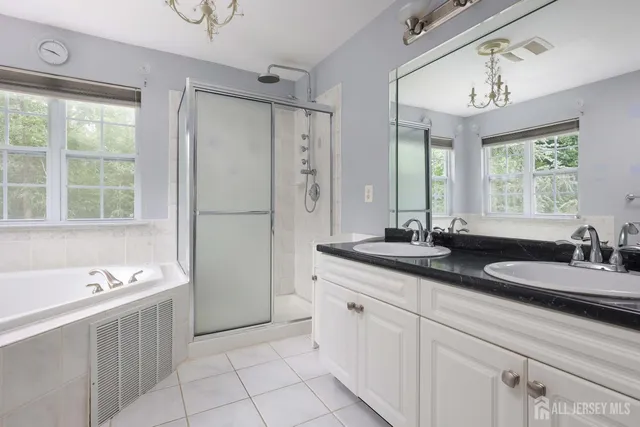 a spacious bathroom with a granite countertop sink mirror and a bathtub