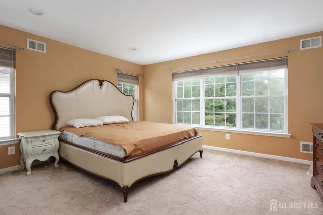 a spacious bedroom with a bed and a window