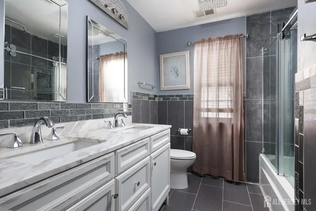 a bathroom with a double vanity sink toilet and shower
