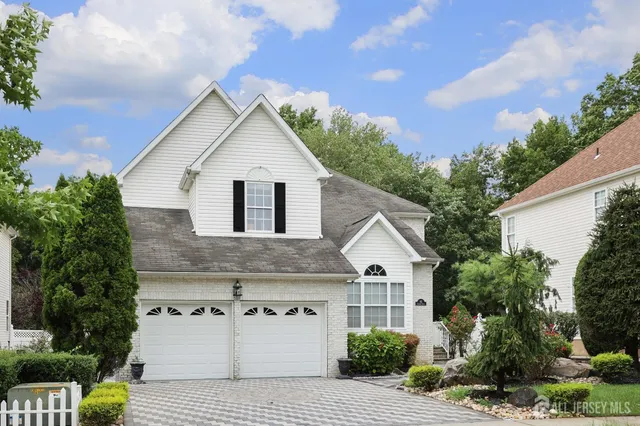 a view of white house with a yard and potted plants