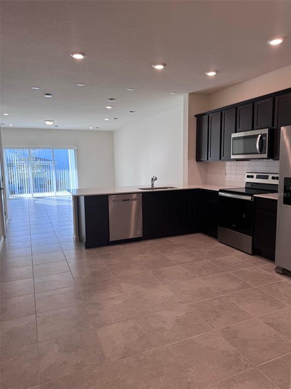 2710 Fetching Trail Davenport, FL 33896 - Photo 2 of 20 a large kitchen with stainless steel appliances granite countertop a sink and cabinets