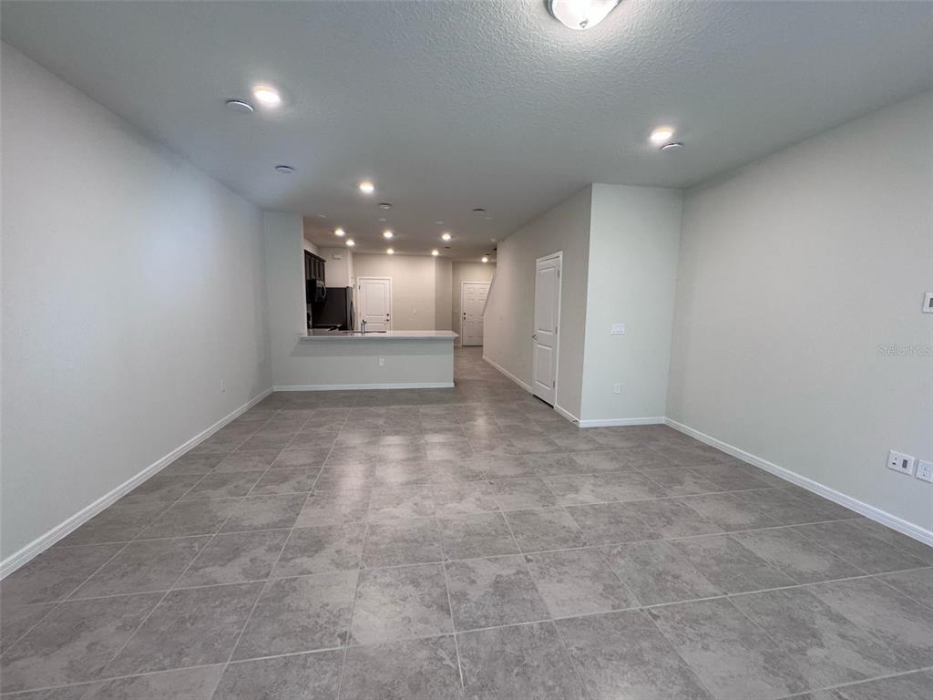 2710 Fetching Trail Davenport, FL 33896 - Photo 4 of 20 an empty room with a kitchen