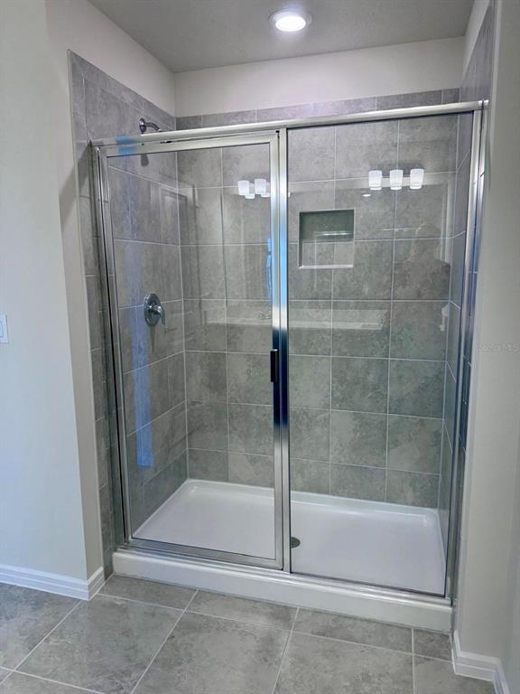 2710 Fetching Trail Davenport, FL 33896 - Photo 9 of 20 a bathroom that has a glass shower door