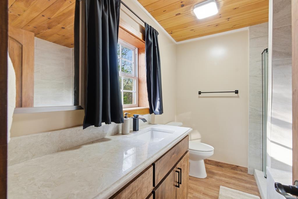 1843 Old Mobile Road McCaysville, GA 30555 - Photo 31 of 41 a bathroom with a granite countertop sink and a large mirror