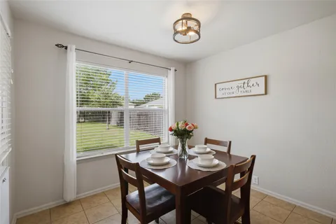 a view of a dining room with a table and chairs
