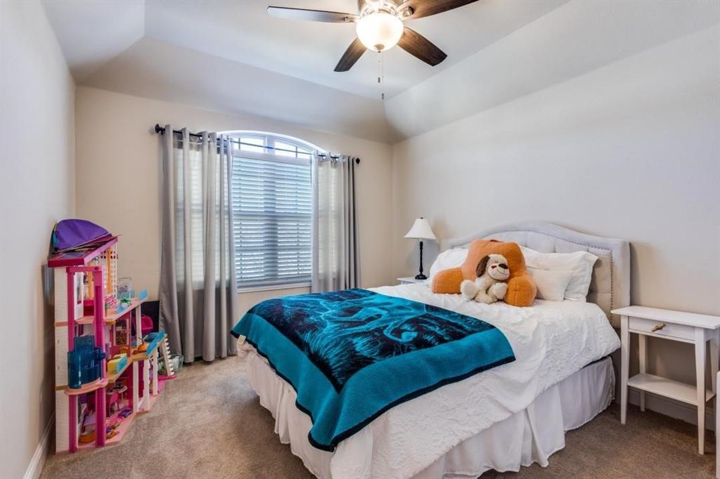 2821 Inn Kitchen Way McKinney, TX 75071 - Photo 15 of 24 Arch-top window with blinds, ceiling fan with integrated lighting, carpeted flooring, tray ceiling, and upholstered headboard