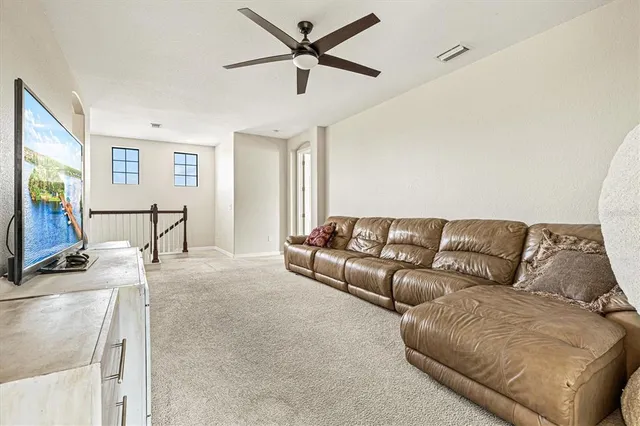 a view of a workspace with furniture and a ceiling fan