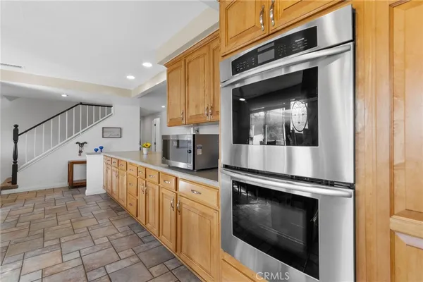 a kitchen with granite countertop white cabinets and stainless steel appliances