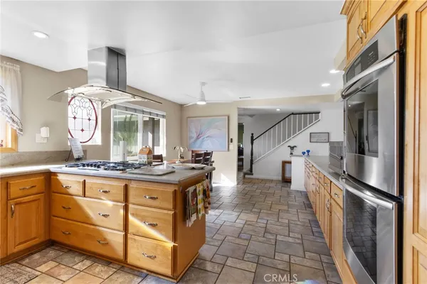 a kitchen with granite countertop a stove a sink and a refrigerator