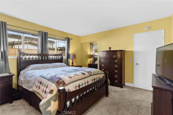 a bedroom with a bed and a flat tv screen on dresser