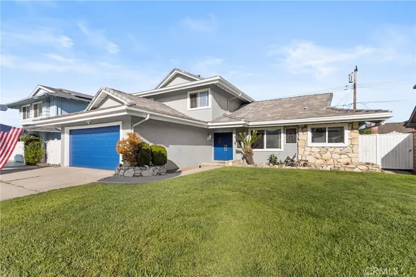 a front view of a house with a garden and yard