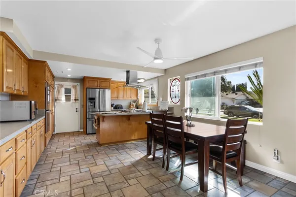 a kitchen with stainless steel appliances a dining table chairs and granite counter tops