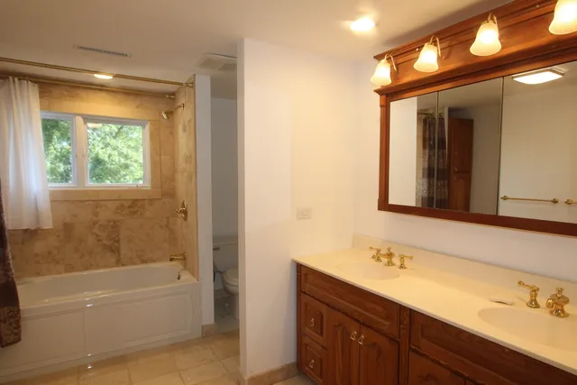 a bathroom with a tub sink and mirror