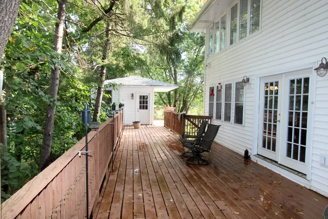 a view of a patio with table and chairs under an umbrella with wooden floor