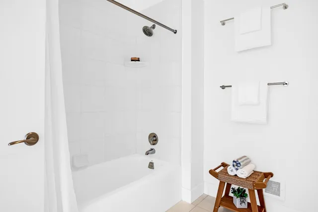 a bathroom with a tub shower and a sink