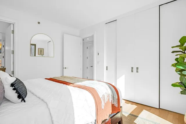 a bedroom with a bed and a potted plant