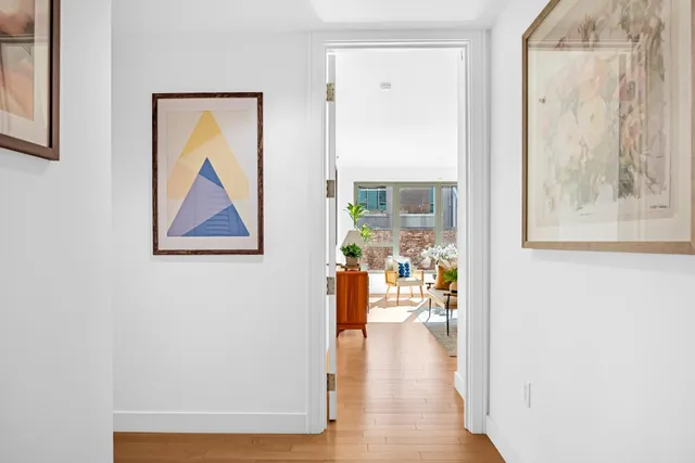 a view of a livingroom with wooden floor and a refrigerator