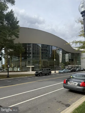 a living room with furniture a flat screen tv and kitchen view