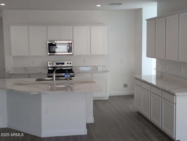 a kitchen with stainless steel appliances a sink a stove a microwave a sink and cabinets