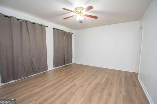a view of an empty room with a window and a fan