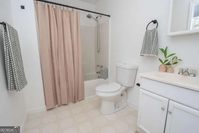 a bathroom with a toilet a sink and shower