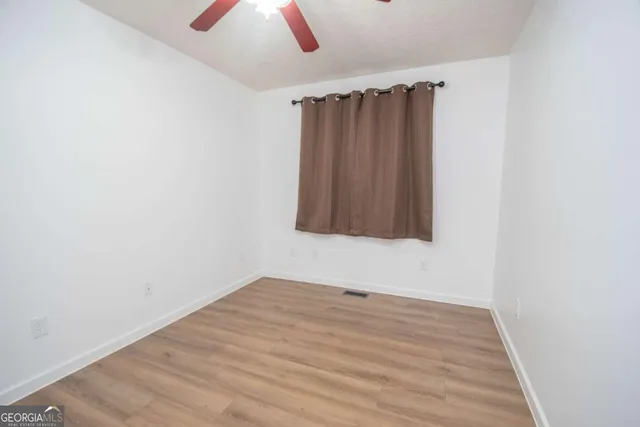 a view of an empty room with wooden floor