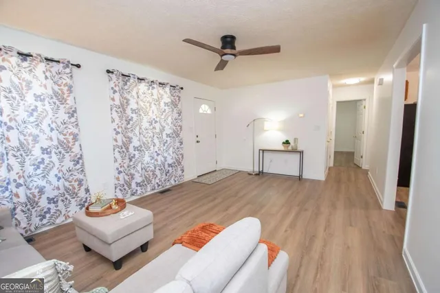 a view of a living room hardwood floor and a ceiling fan