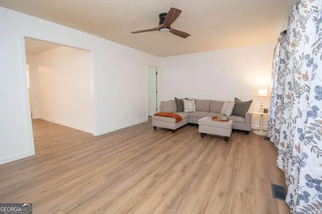 a living room with furniture and a wooden floor