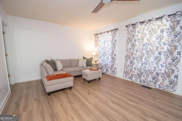 a living room with furniture and a wooden floor