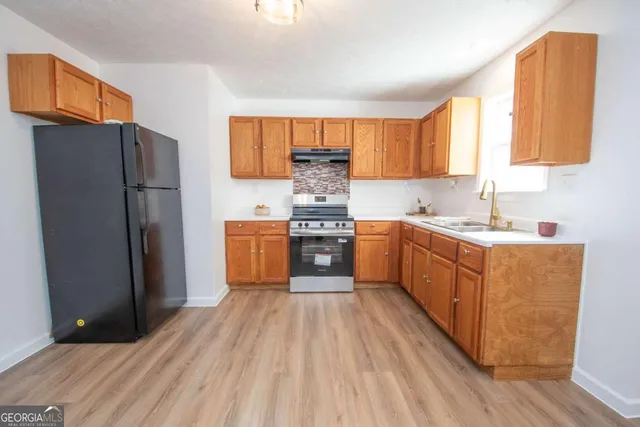 a kitchen with stainless steel appliances a refrigerator sink and cabinets