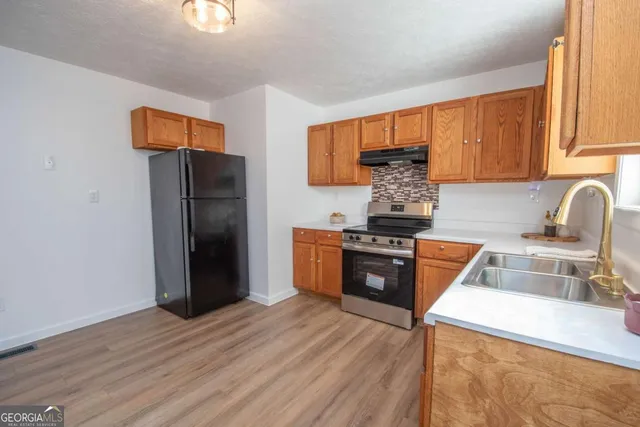 a kitchen with granite countertop a refrigerator stove and sink