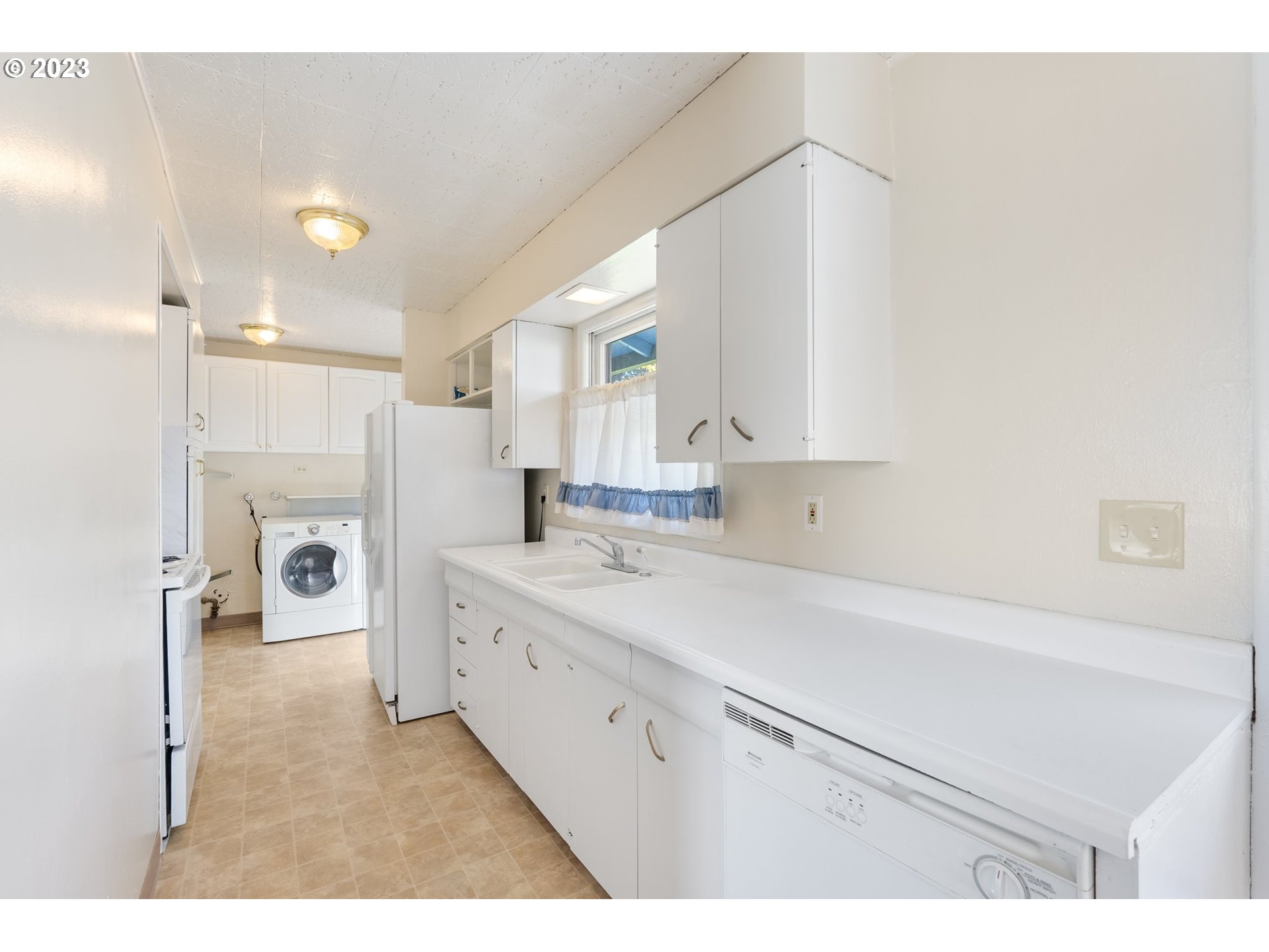 477 Northwest Chesser Road Stevenson, WA 98648 - Photo 28 of 40 a kitchen with a sink a refrigerator and white cabinets