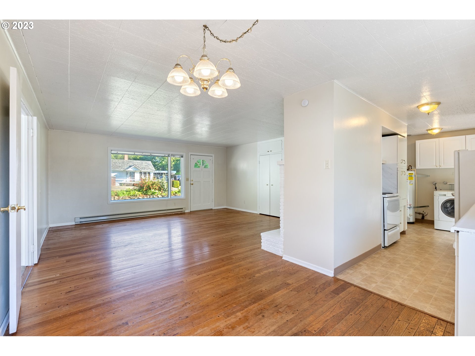 477 Northwest Chesser Road Stevenson, WA 98648 - Photo 29 of 40 a view of an empty room and a kitchen with wooden floor