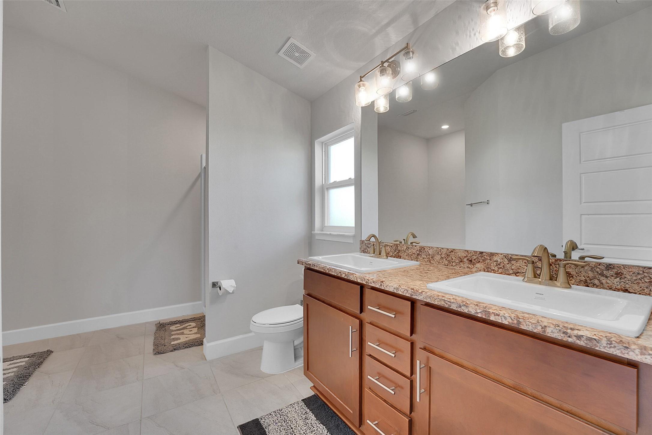 8600 Merano Avenue Fort Pierce, FL 34951 - Photo 13 of 22 a bathroom with a granite countertop sink a toilet and a mirror