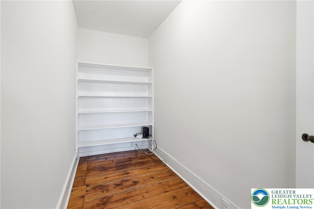 4682 Steuben Road Bethlehem, PA 18020 - Photo 9 of 79 A versatile space with rich hardwood flooring and built-in shelving, ready for your customization.