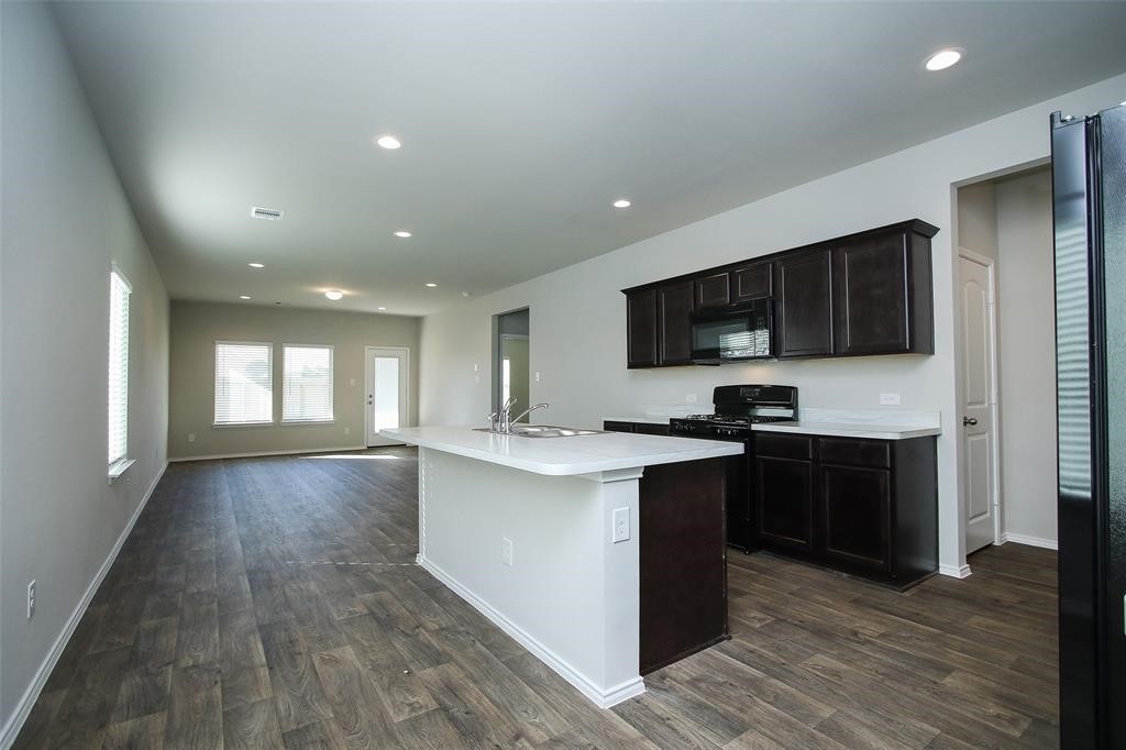 4023 Wyanngate Drive Spring, TX 77373 - Photo 6 of 23 a kitchen with stainless steel appliances granite countertop a stove top oven a sink dishwasher and a microwave oven on the wooden floor